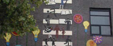 De oud-directeur van De Bloemaert en de cultuurcoördinator wilden graag zichtbaar maken waar die school voor staat. Toen hebben ze stichting BIK Collectief gevraagd om een wandkunstwerk te ontwerpen en te maken.