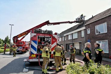 Brandweer die de zolderbrand blust