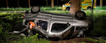 Man komt op zijn kop in sloot terecht, na botsing met boom