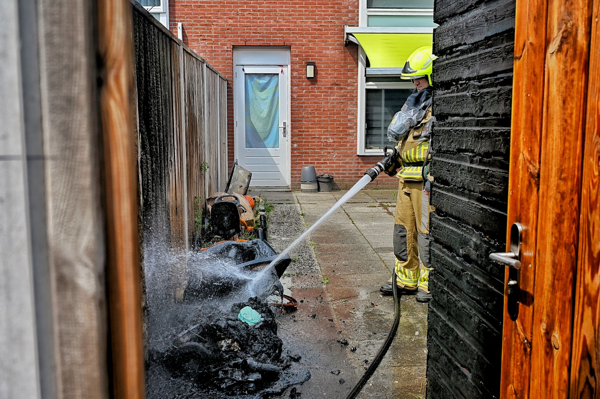 Brand in container zorgt voor grote schade aan schutting en berging